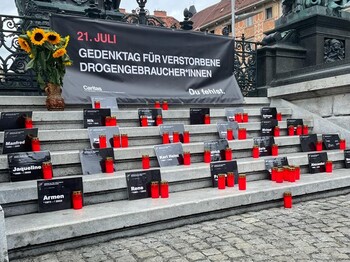 Kerzen und ein Plakat erinnern am Grazer Hauptplatz an verstorbene Drogengebraucher*innen