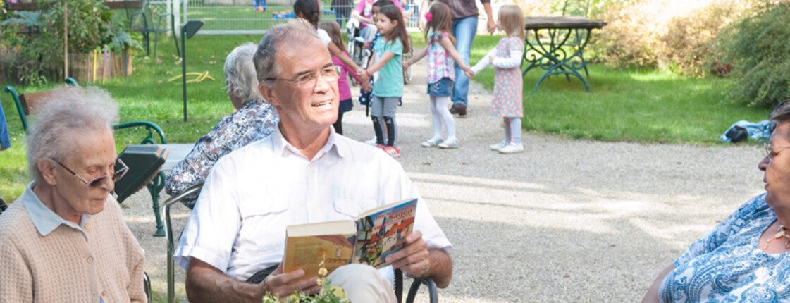 Freiwillige lesen den Bewohnerinnen und Bewohnern vor