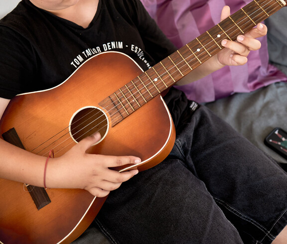 Gitarrespielender Jugendlicher im Sprungbrett