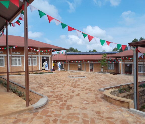 Blick auf Gebäude und Innenhof der neu eröffneten Ausbildungsstätte mit feierlichen burundischen Fahnen 