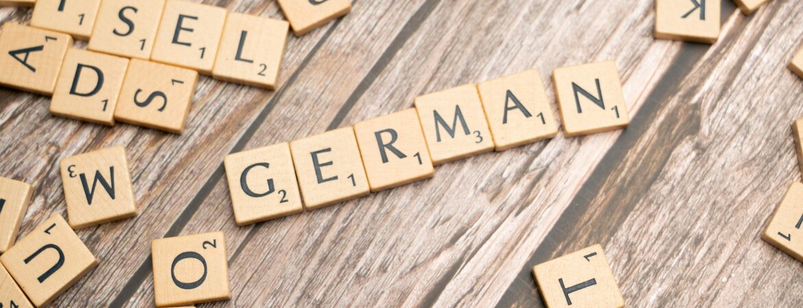 Mit Scrabble Buchstaben wurde auf einem Holztisch das Wort "GERMAN" gelegt.
