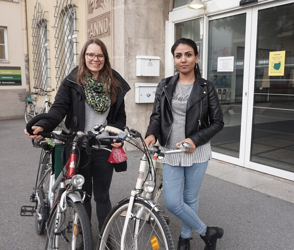 Bike-Patin und begleitete Frau übernehmen Fahrräder bei der Caritas