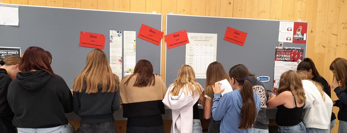 Schülerinnen stehen vor einer Schultafel