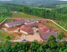 Blick von oben auf das Gelände und die Gebäude des neuen Ausbildungszentrums, eingebettet in grüne Natur. 