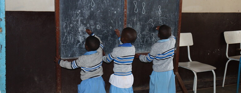 Waisenkinder in Burundi schreiben an einer Schultafel