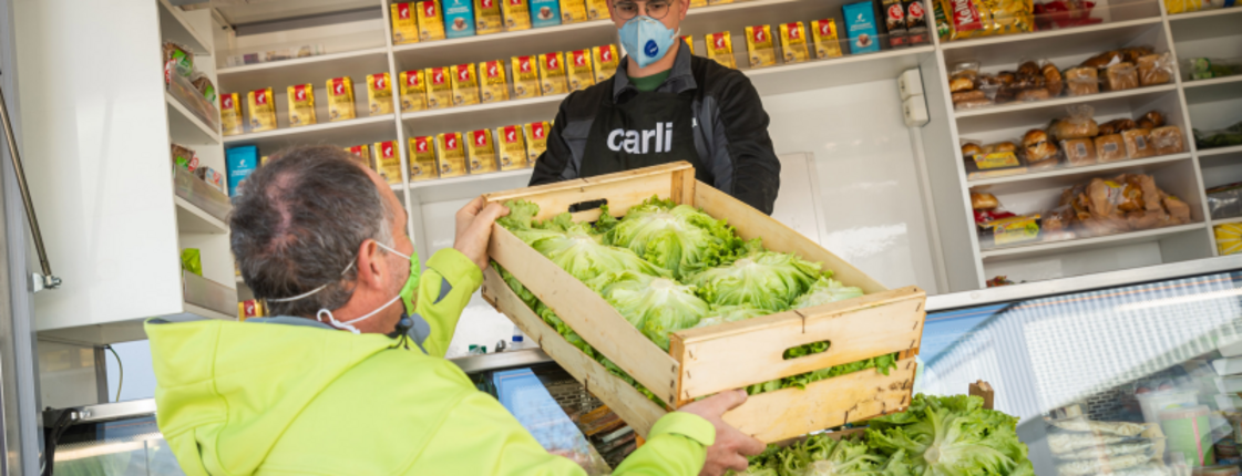 Krauthaeupl-Bauer übergibt Salatspende an Caritas-Mitarbeiter für die Lebensmittelnotausgabe
