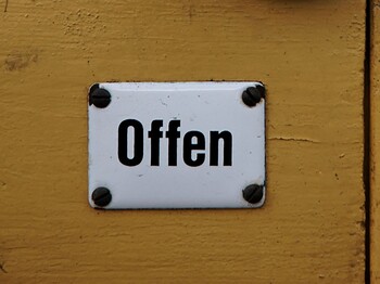 Ein Schild mit dem Schriftzug "Offen" auf einer Tür