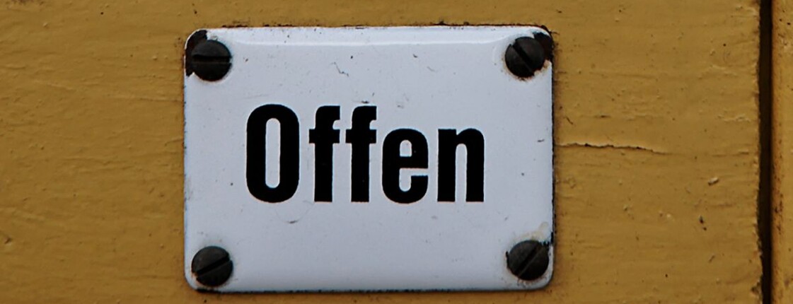 Ein Schild mit dem Schriftzug "Offen" auf einer Tür