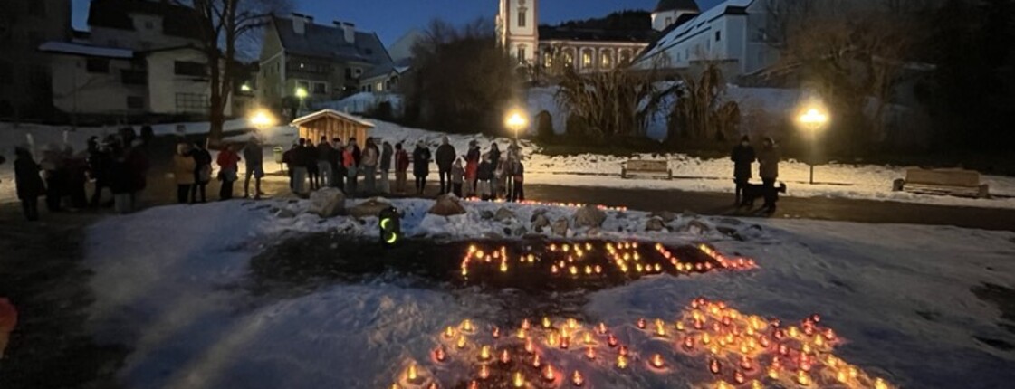 Vor der Kirche von Mariazell bei Dunkelheit stehen Teelichter die "M-Zell" schreiben