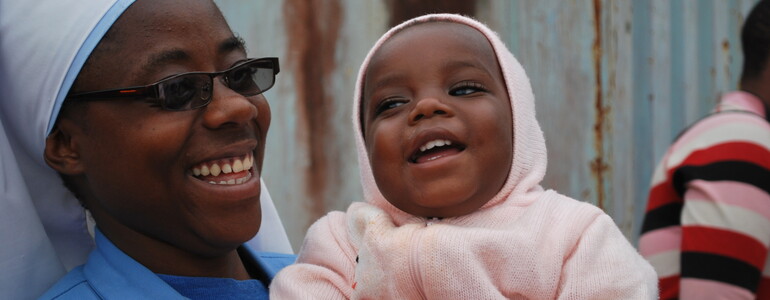 Klosterschwester mit Waisenkind am Arm in Burundi 