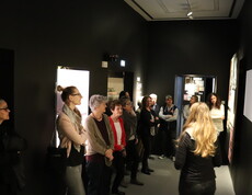 Eine Gruppe von Menschen besucht ein Museum und betrachtet ein Kunstwerk.