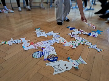 Eine Papiergirlande mit Zeichnungen und Notizen aus dem Workshop am Boden eines Raumes