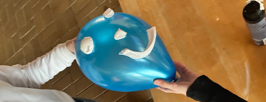 Einem blauen Luftballon wurde mit Rasierschaum ein Gesicht aufgemalen