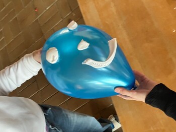 Einem blauen Luftballon wurde mit Rasierschaum ein Gesicht aufgemalen