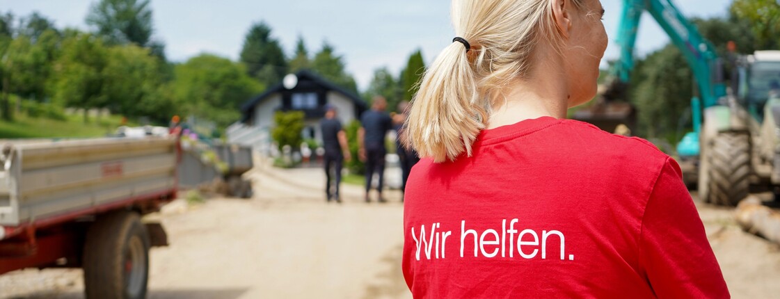 Caritas Mitarbeiterin bei den Aufräumarbeiten nach dem Unwetter