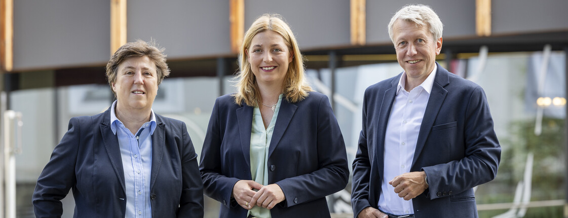 Das Direktorium der Caritas Steiermark im Anzug gekleidet lächelt in die Kamera