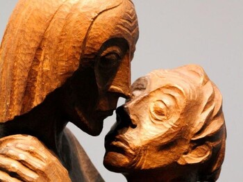 Pfarrcaritas-Tag - Statue von Ernst Barlach Eine Holzstatue, zwei Männer umarmen sich.