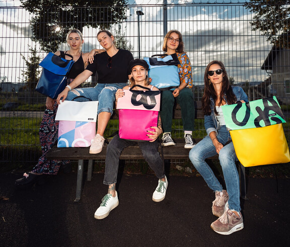 Eine Menschengruppe mit ihren Planenrucksäcken von tag.werk