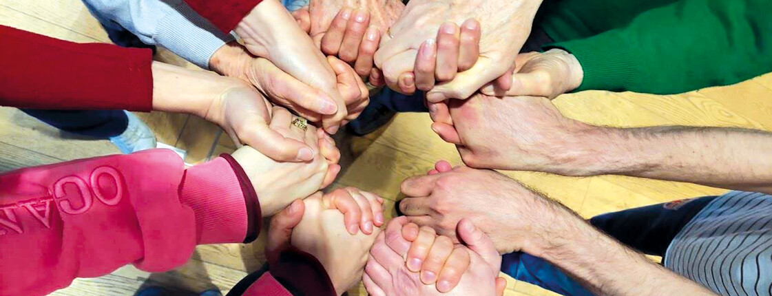 2026_BewegendeBegegnungen_cCaritasTirol Menschen verschiedenen Alters reichen sich gemeinsam die Hände