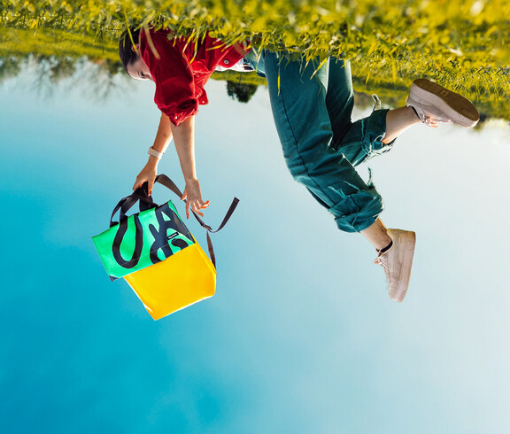 Ein verkehrtes Bild in dem jemand den tag.werk Rucksack nach unten baumeln lässt.