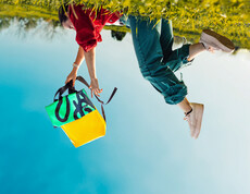 Ein verkehrtes Bild in dem jemand den tag.werk Rucksack nach unten baumeln lässt.