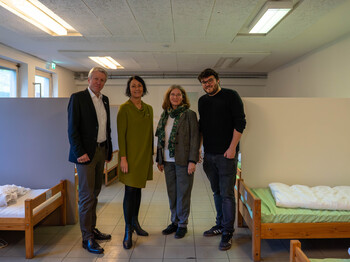 Von links nach rechts: Thomas Ferk, Vizedirektor Caritas Steiermark; Martina Schröck, Obfrau der VinziWerke Österreich; Elke Kahr, Bürgermeisterin Stadt Graz; Jakob Url (Winternotschlafstelle Caritas Steiermark) vor Ort in einem Schlafsaal der Caritas Winternotschlafstelle.