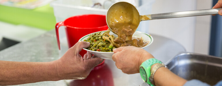 Ein Suppenteller wird mit Suppe befüllt