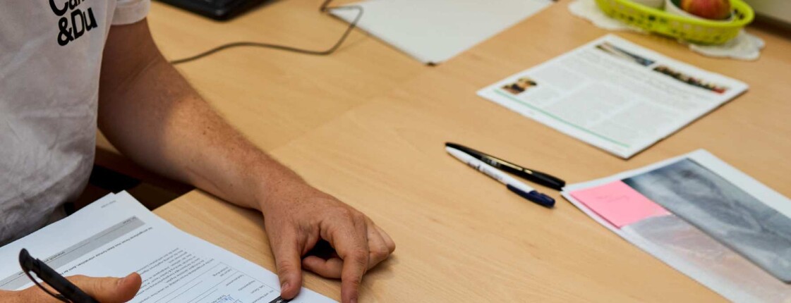 Mann füllt ein Formular aus in der Caritas Energieberatung