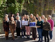 Gruppenfoto der Erasmus Teilnehmenden. 2 Personen halten das Logo des Projekts "Gemeinsam Engagiert" und die EU Flagge in der Hand. 