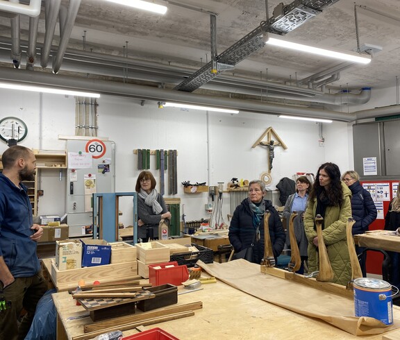 Foto zeigt einige Erasmus-Teilnehmende, die zu Besuch in einer Holzwerkstatt sind.