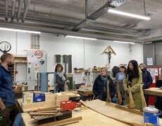 Foto zeigt einige Erasmus-Teilnehmende, die zu Besuch in einer Holzwerkstatt sind.
