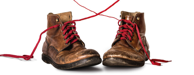Lederschuhe mit roten Schnürsenkeln, die ein Herz formen 