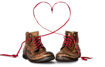 Lederschuhe mit roten Schnürsenkeln, die ein Herz formen 