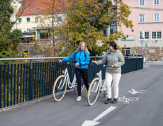Zwei Projektteilnehmerinnen der Bike Buddys mit Fahrrad am Radweg