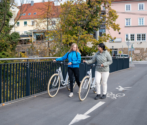 Zwei Projektteilnehmerinnen der Bike Buddys mit Fahrrad am Radweg