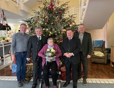 Hausleiter Josef Url, Bürgermeister ÖkR Josef Niggas, Vizebürgermeister Robert Sauer und BPO 2. Landtagspräsident Werner Amon, MBA, stehen nebeneinander und posieren für ein Gruppenfoto. In der Mitte steht Frau Markl, die einen Blumenstrauß in den Händen hält. Hinter der Gruppe ist ein festlich geschmückter Christbaum zu sehen. Die Personen blicken freundlich in die Kamera und stehen in einem offiziellen oder feierlichen Rahmen zusammen. 
