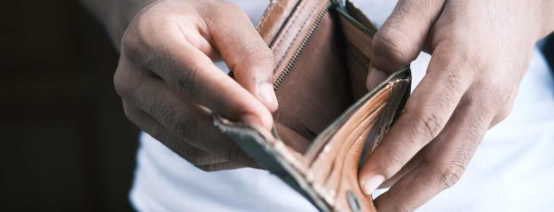 Zwei Hände halten eine leere Geldtasche. 