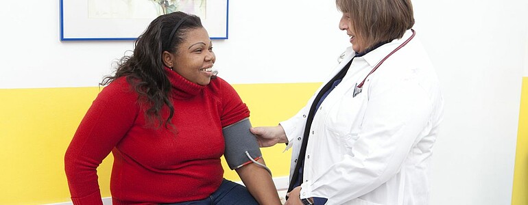 Eine Ärztin misst den Blutdruck einer Patientin.