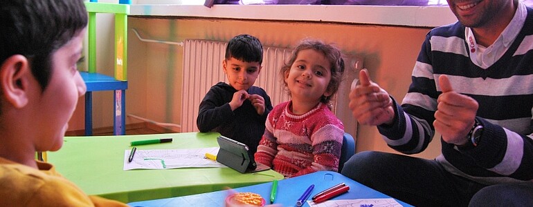 Mitarbeiter des St. Anna Integrationszentrums kümmern sich um Kinder im Flüchtlingscamp Vrashdebna.