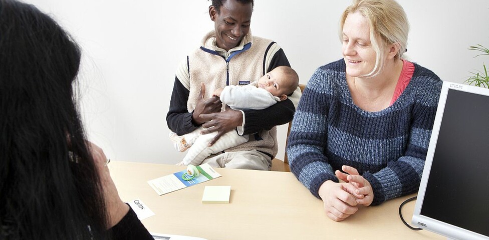 Ein Paar mit Baby bekommt Hilfe in der Sozialberatungsstelle